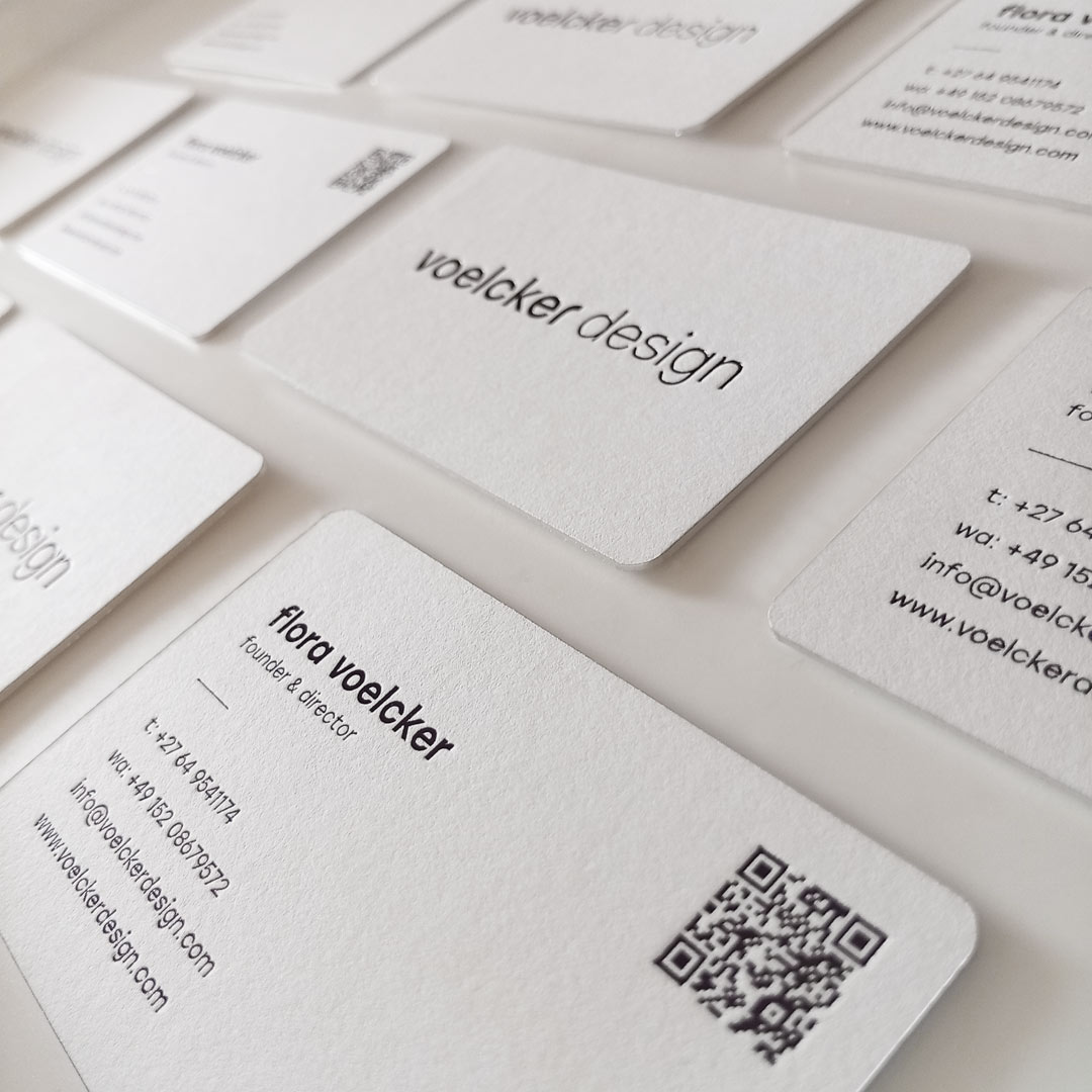 Grid of Minimalist black foiled business cards arranged portrait formation showcasing the black foil logo and contact details