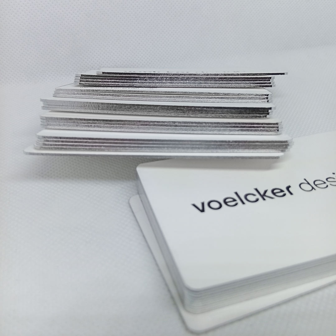 Loosely stacked side view of the silver edge foiled business cards with subtle shine