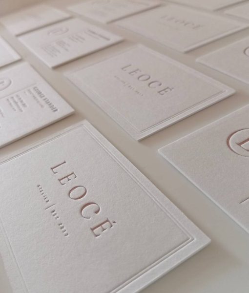 Angled perspective shot of a grid of 10 Leocé Debossed Border Letterpress Business Cards